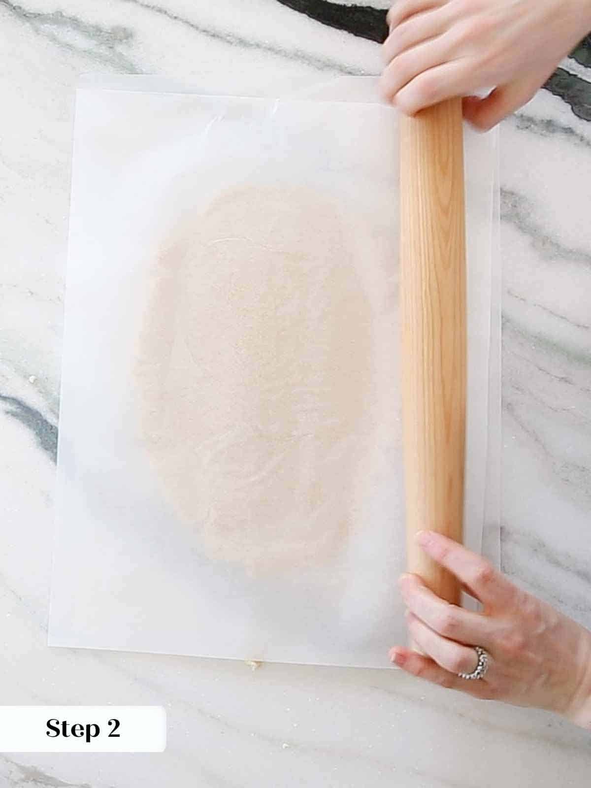 rolling sugar cookie dough between parchment.