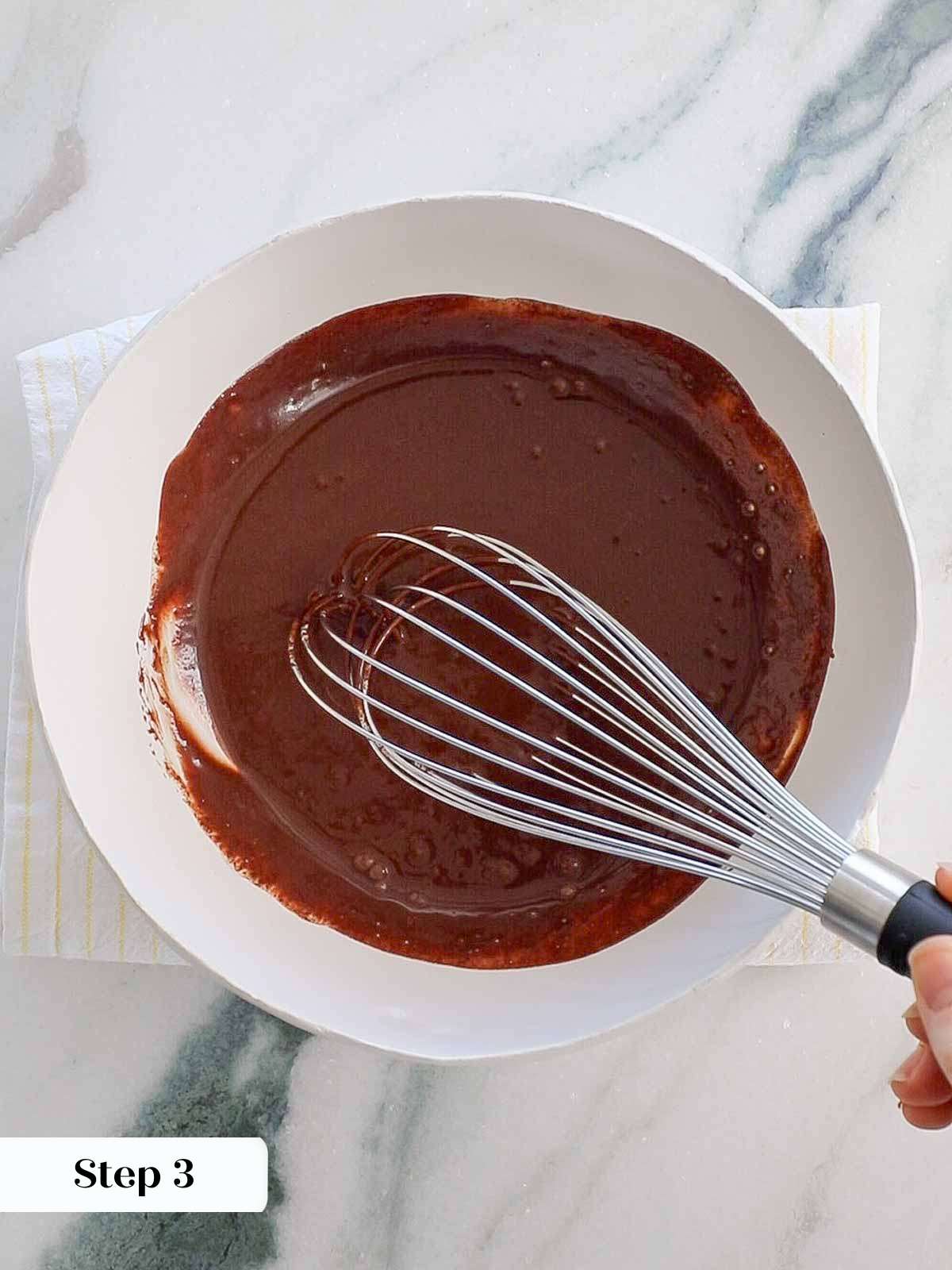 smooth ganache with whisk in white bowl.