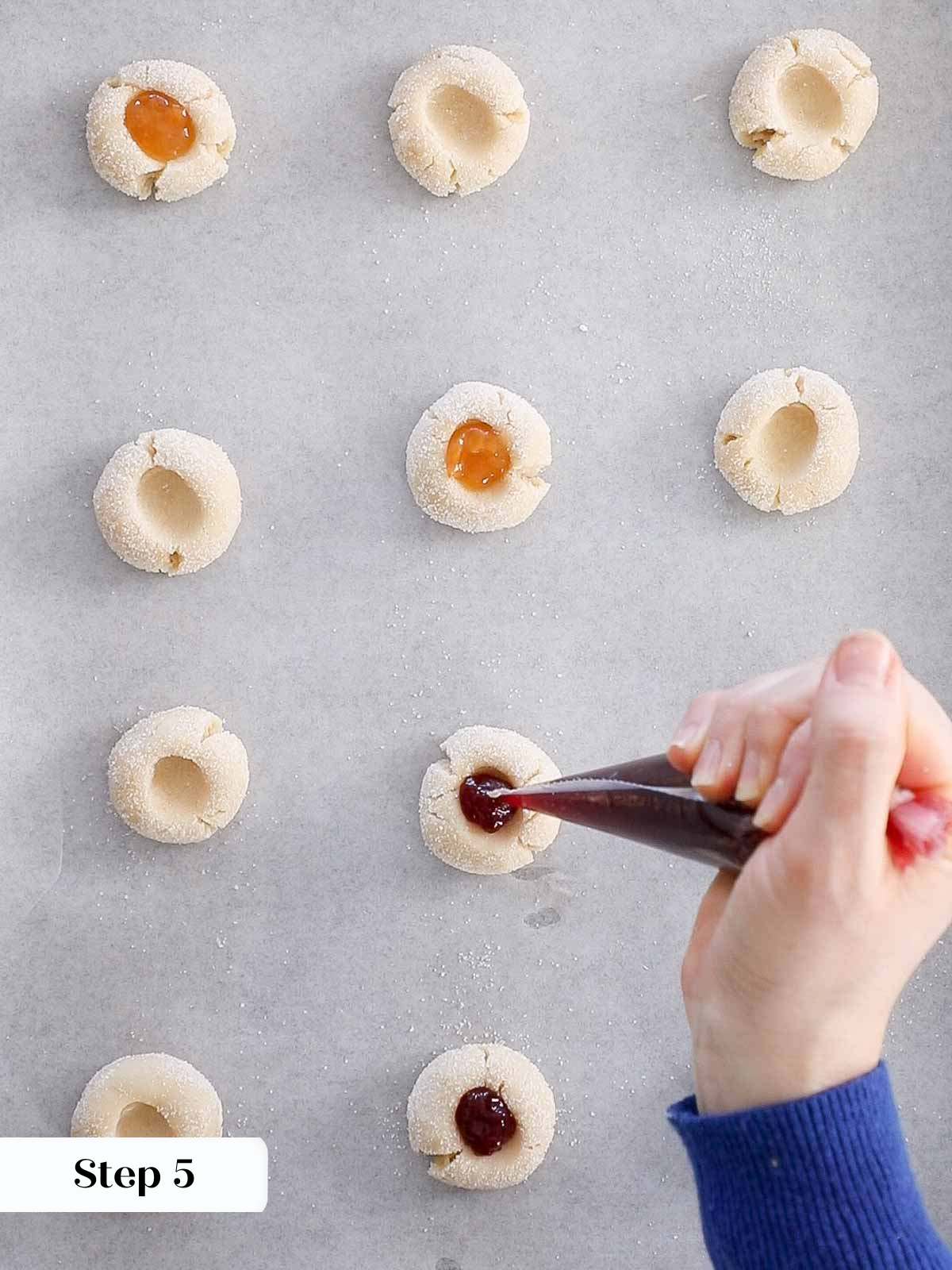filling thumbprints with jam before baking.