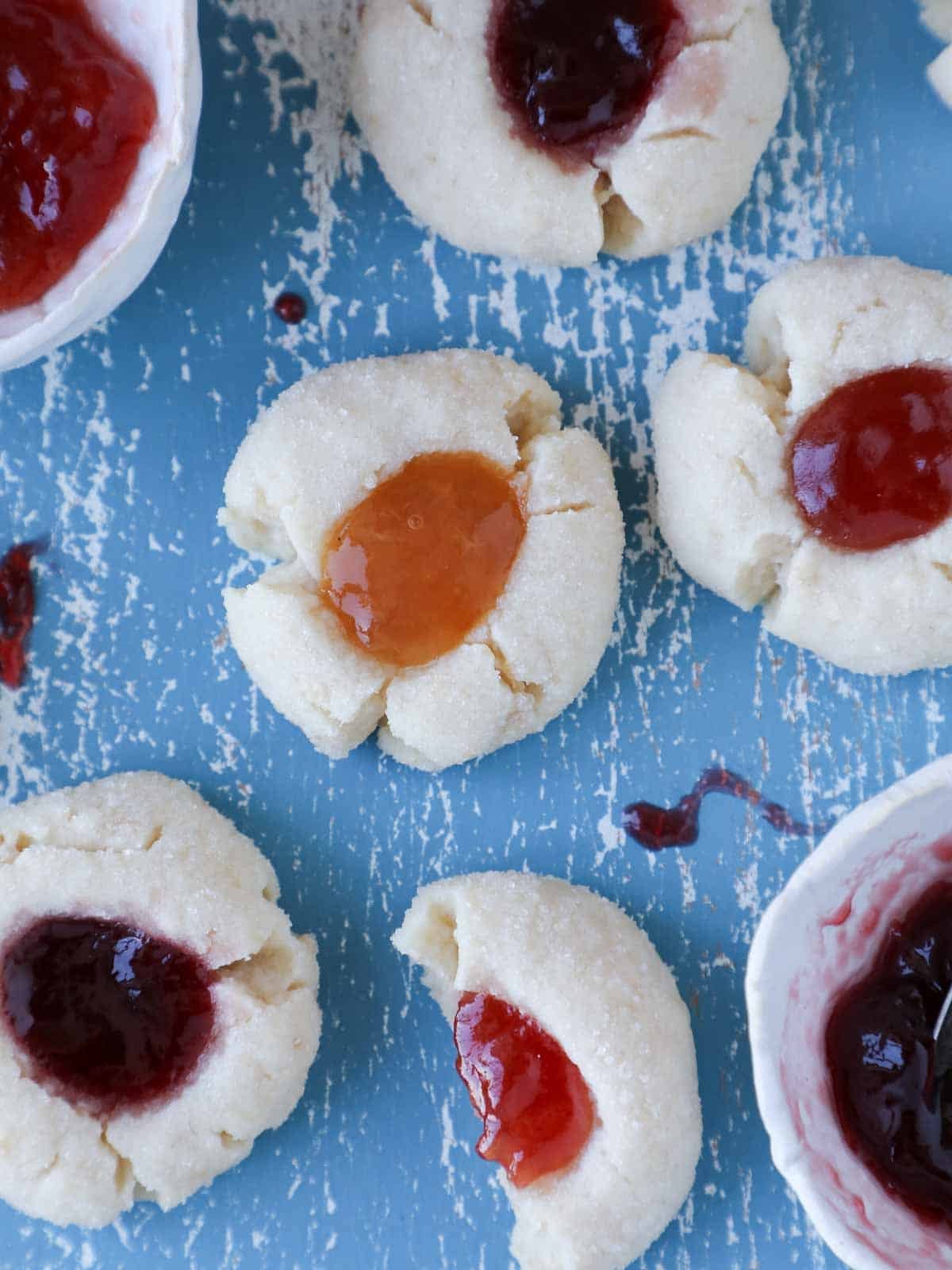thumbprint cookies on blue board with jams. 