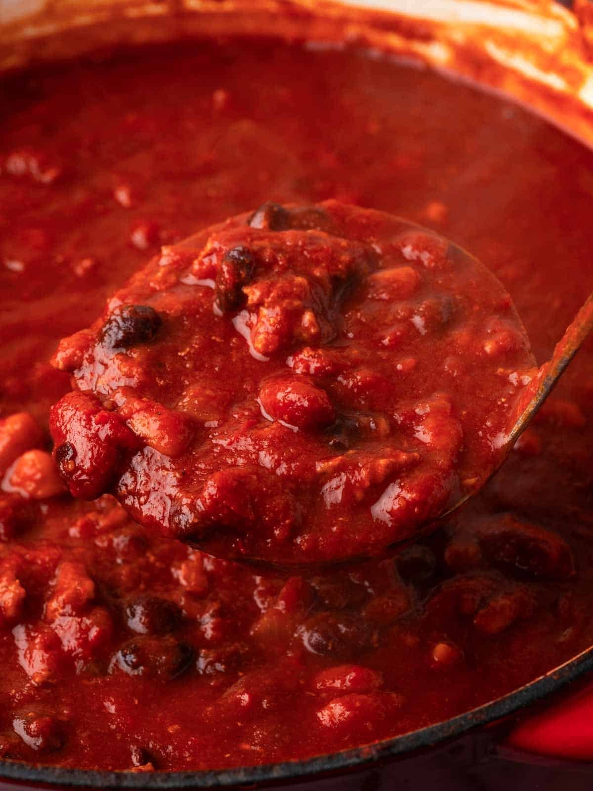scooping chili from dutch oven with ladle.