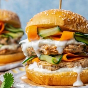 chicken burger stacked with veggies and sauce.