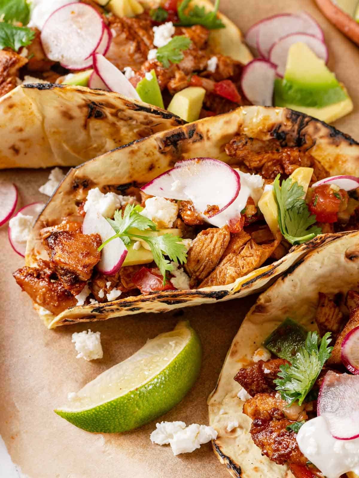 Chicken tacos with a chopped lime wedge.