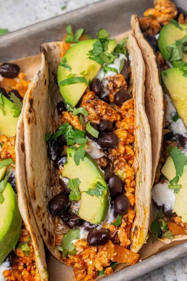 flavorful chicken taco with avocado and chopped cilantro.