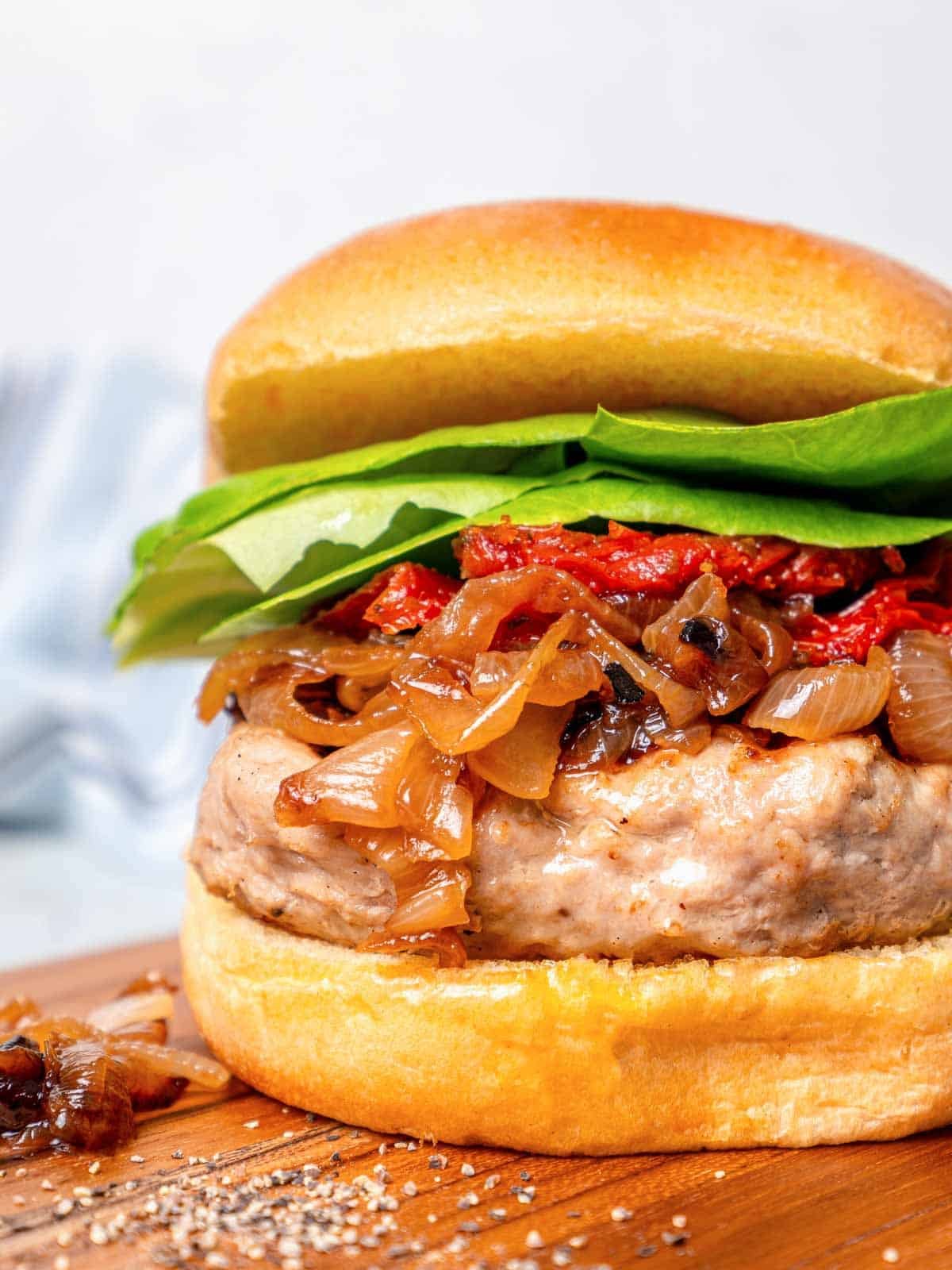 assembled turkey burger with caramelized onions and lettuce. 