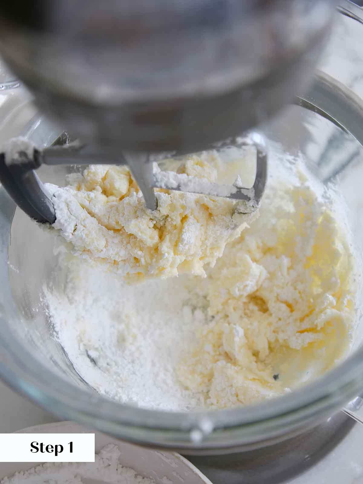 adding sugar to butter in lemon buttercream frosting.