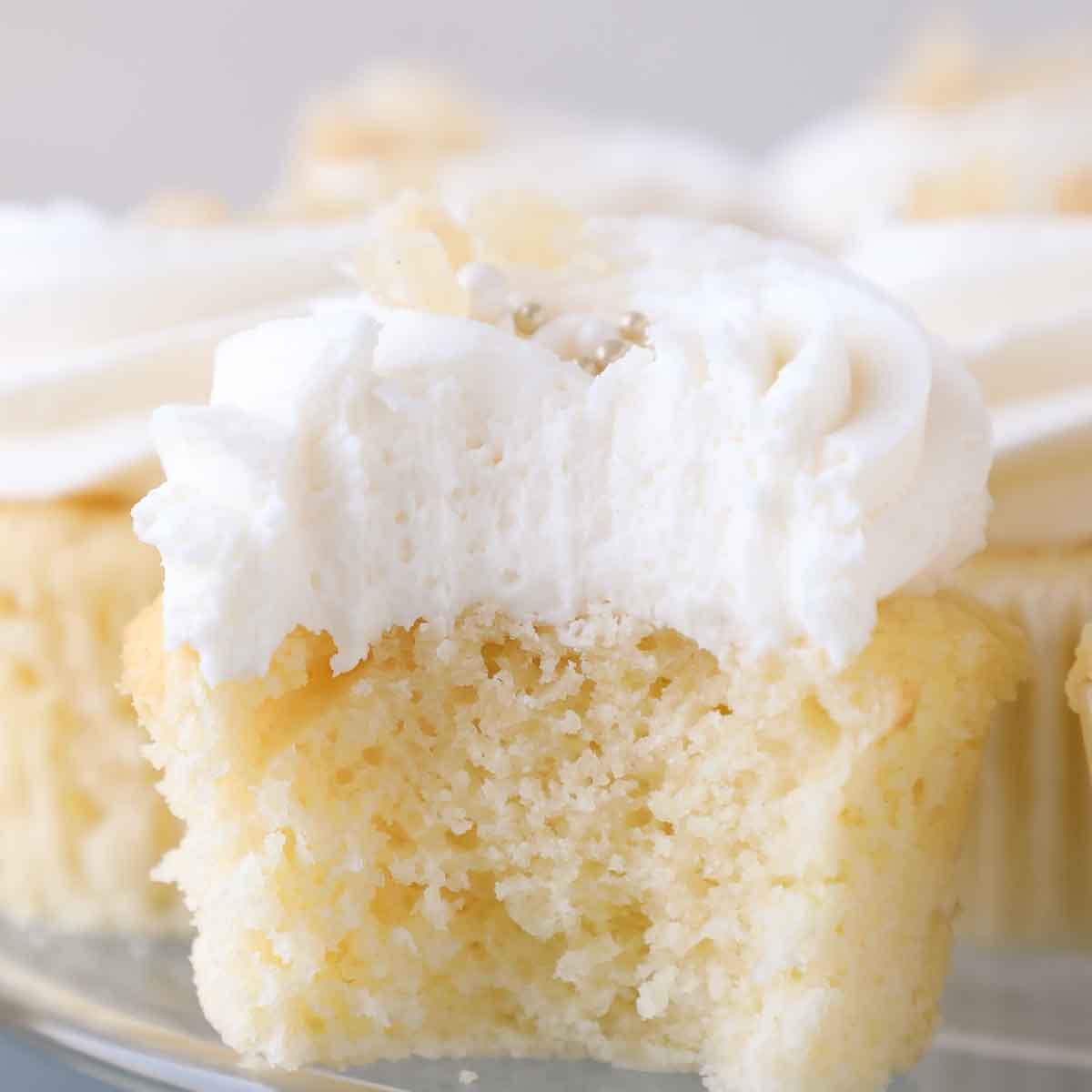 fluffing interior of lemon buttercream frosting on cupcake.