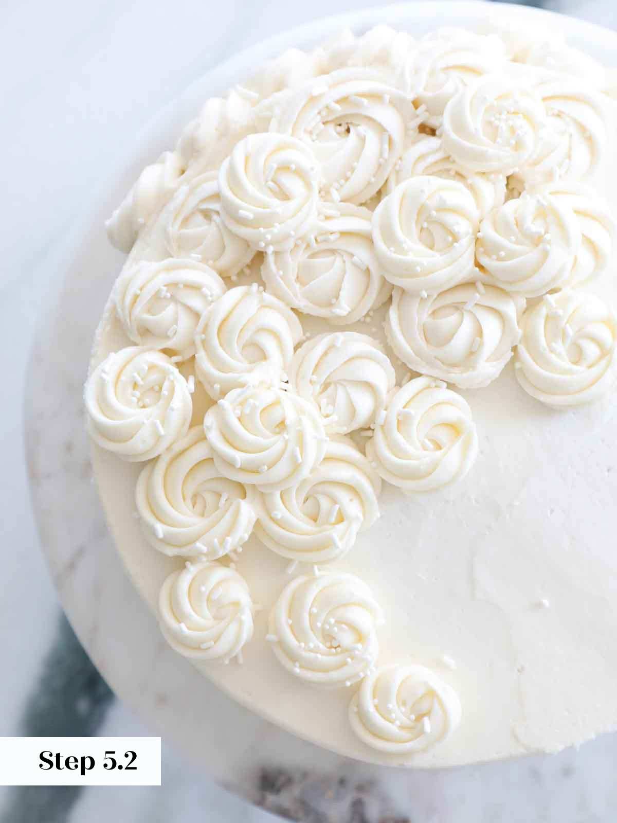 piped vanilla american buttercream rosettes on cake.