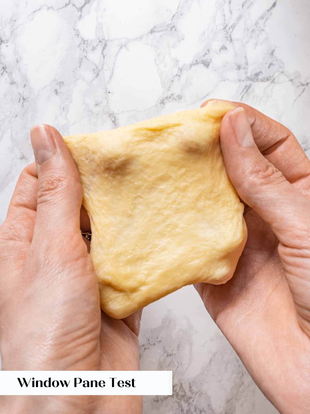 Performing the window pane test on brioche dough.