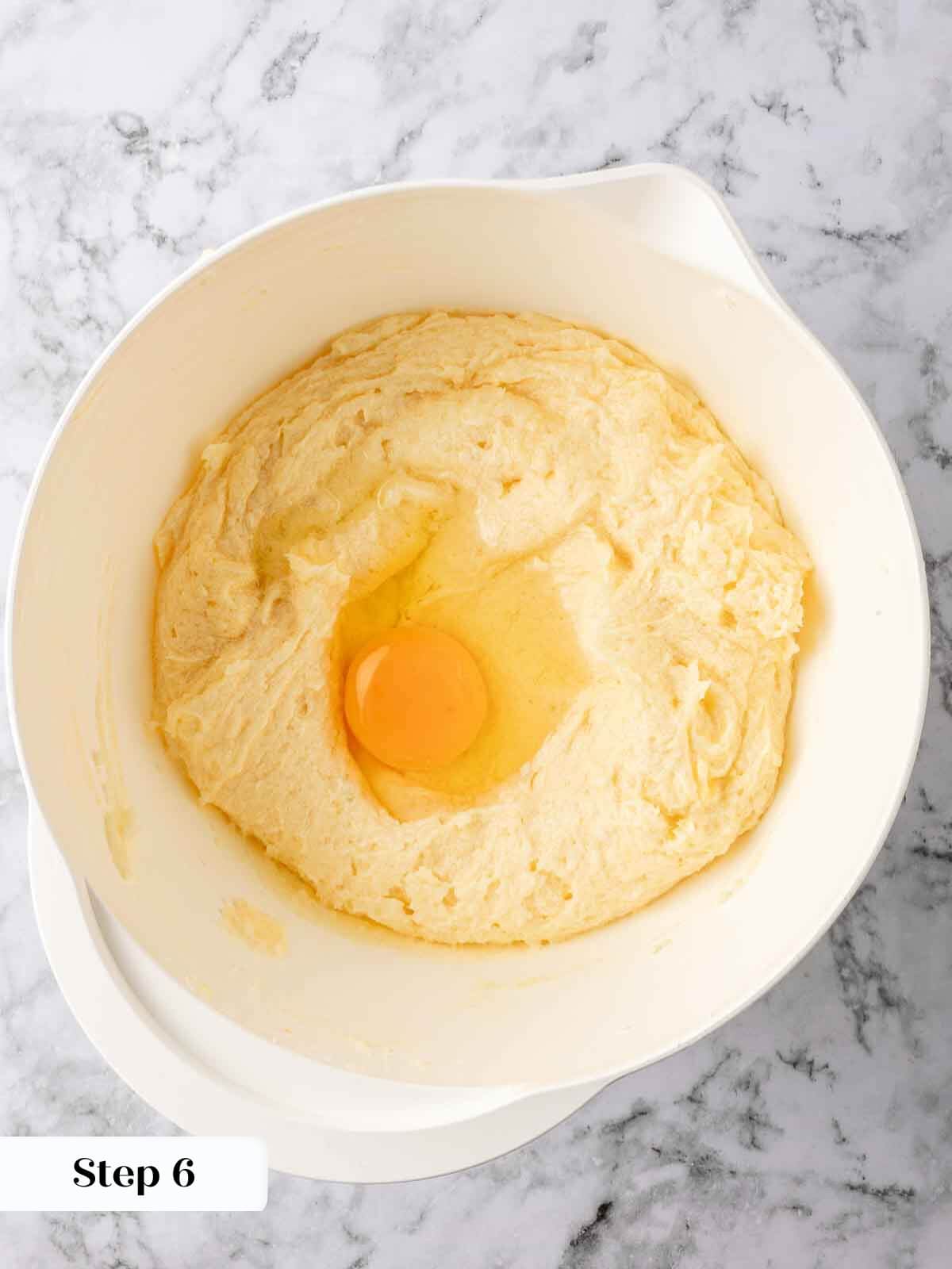 Adding eggs to the lemon pound cake batter.
