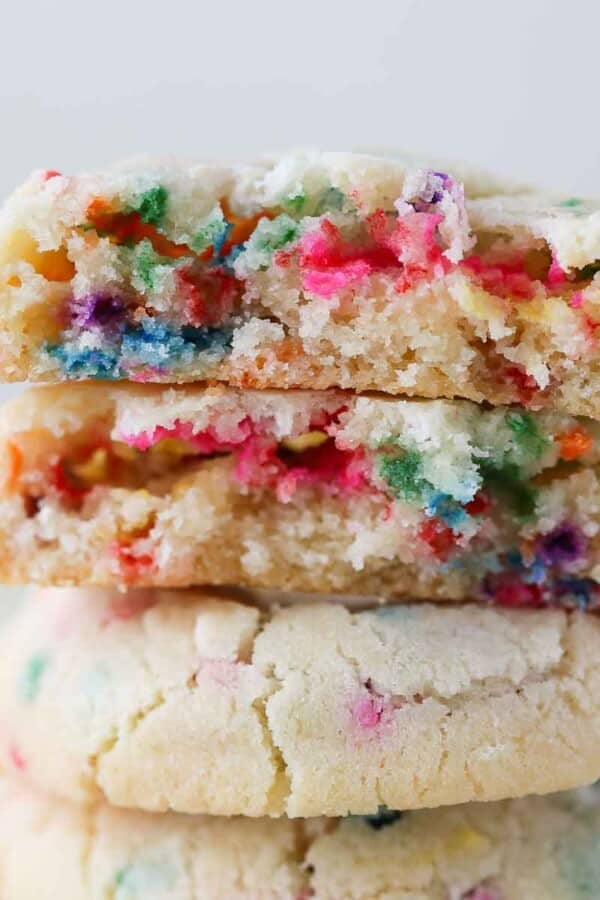 A funfetti cookie broken in half to showcase its chewy interior filled with sprinkles.