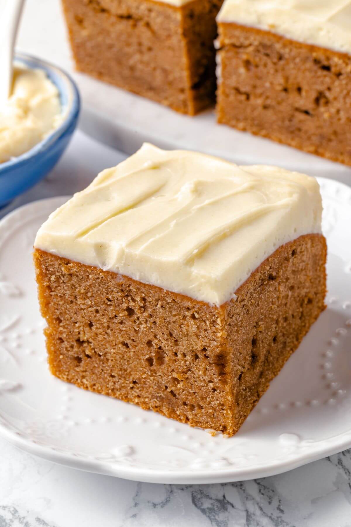 A slice of applesauce cake served on a white plate.