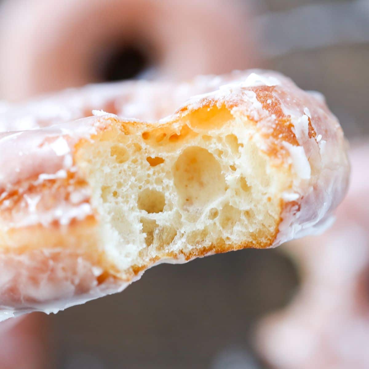 A Krispy Kreme donut with a bite taken out, showing its soft interior.