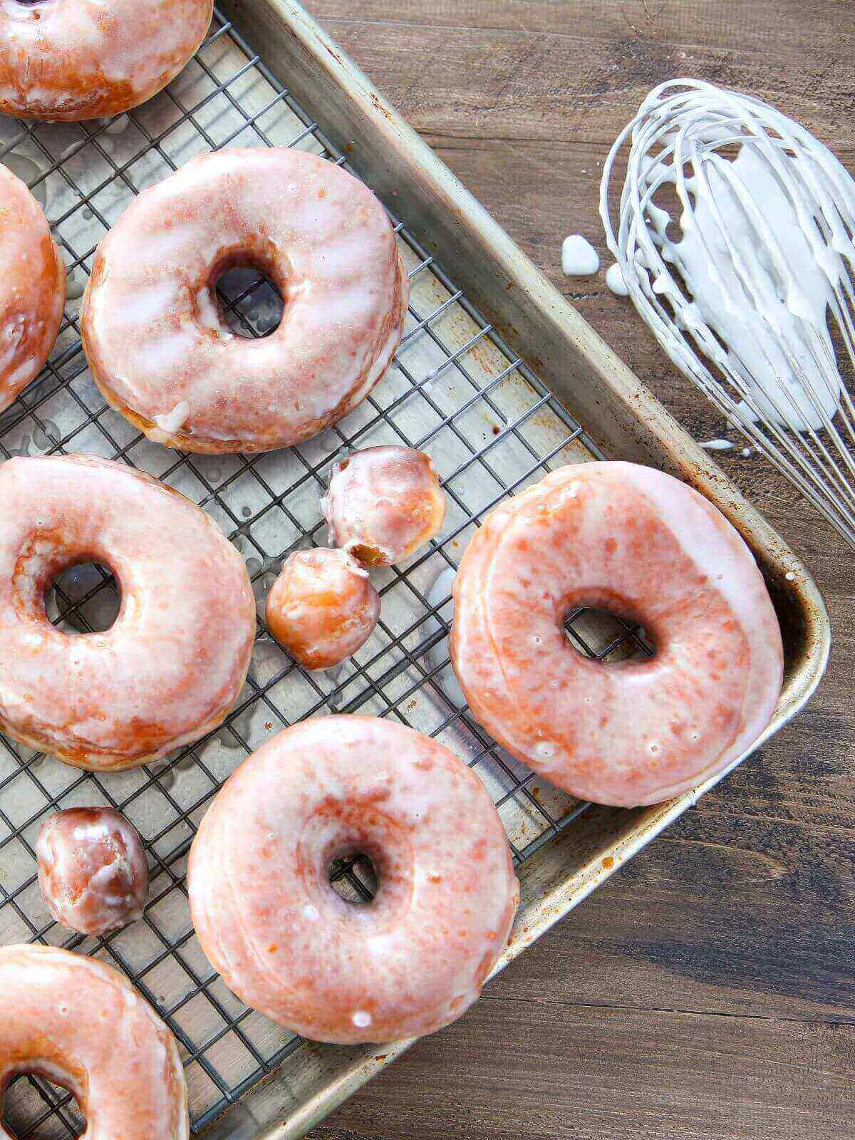 A close-up of perfectly glazed Krispy Kreme donuts, shining under the light.