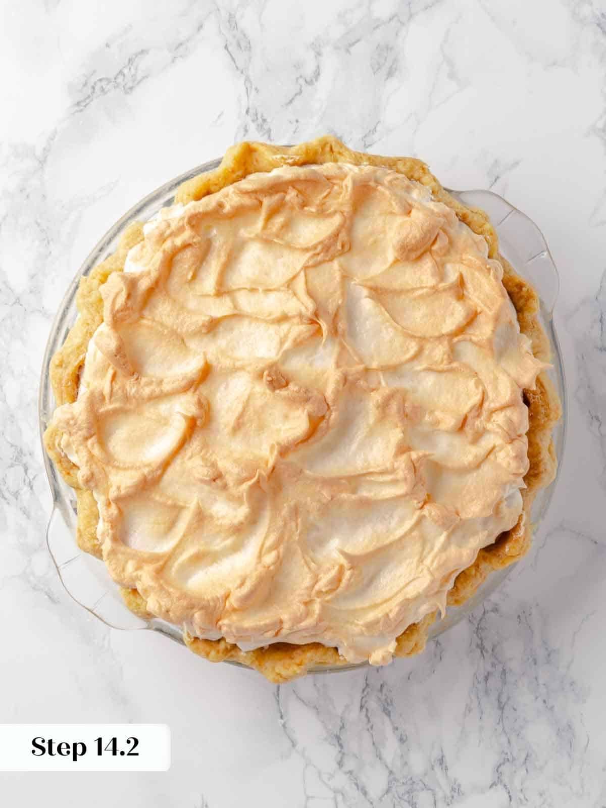 A close-up shot of bruleed meringue atop a lemon pie, showing the caramelized peaks.