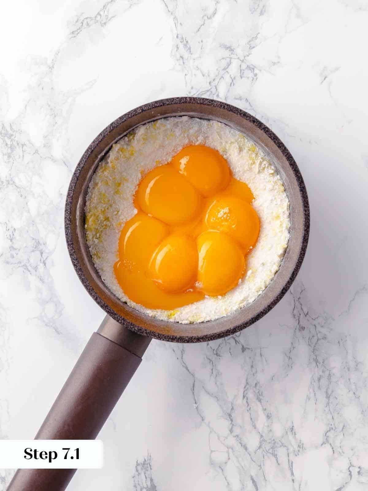 Egg yolks being added to the lemon mixture, bringing the pie filling together.