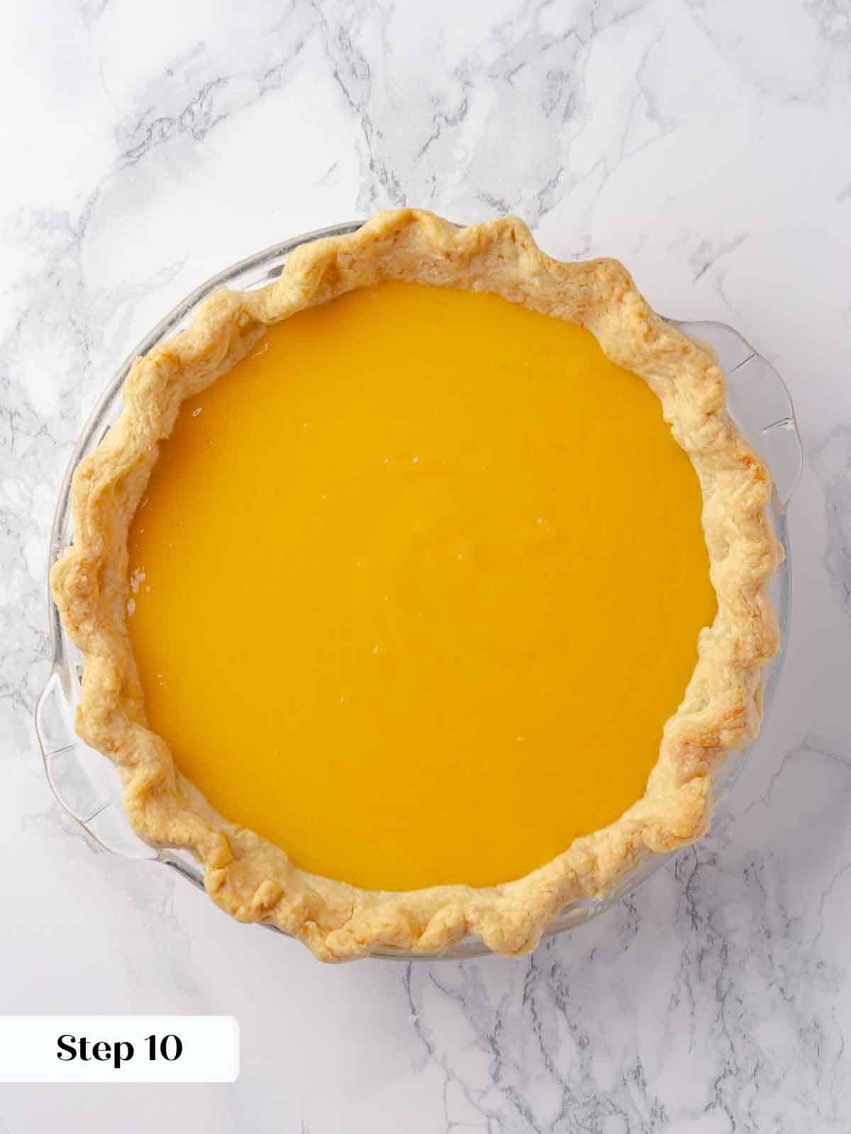 Lemon pie filling being poured into a pre-baked crust, golden and smooth.