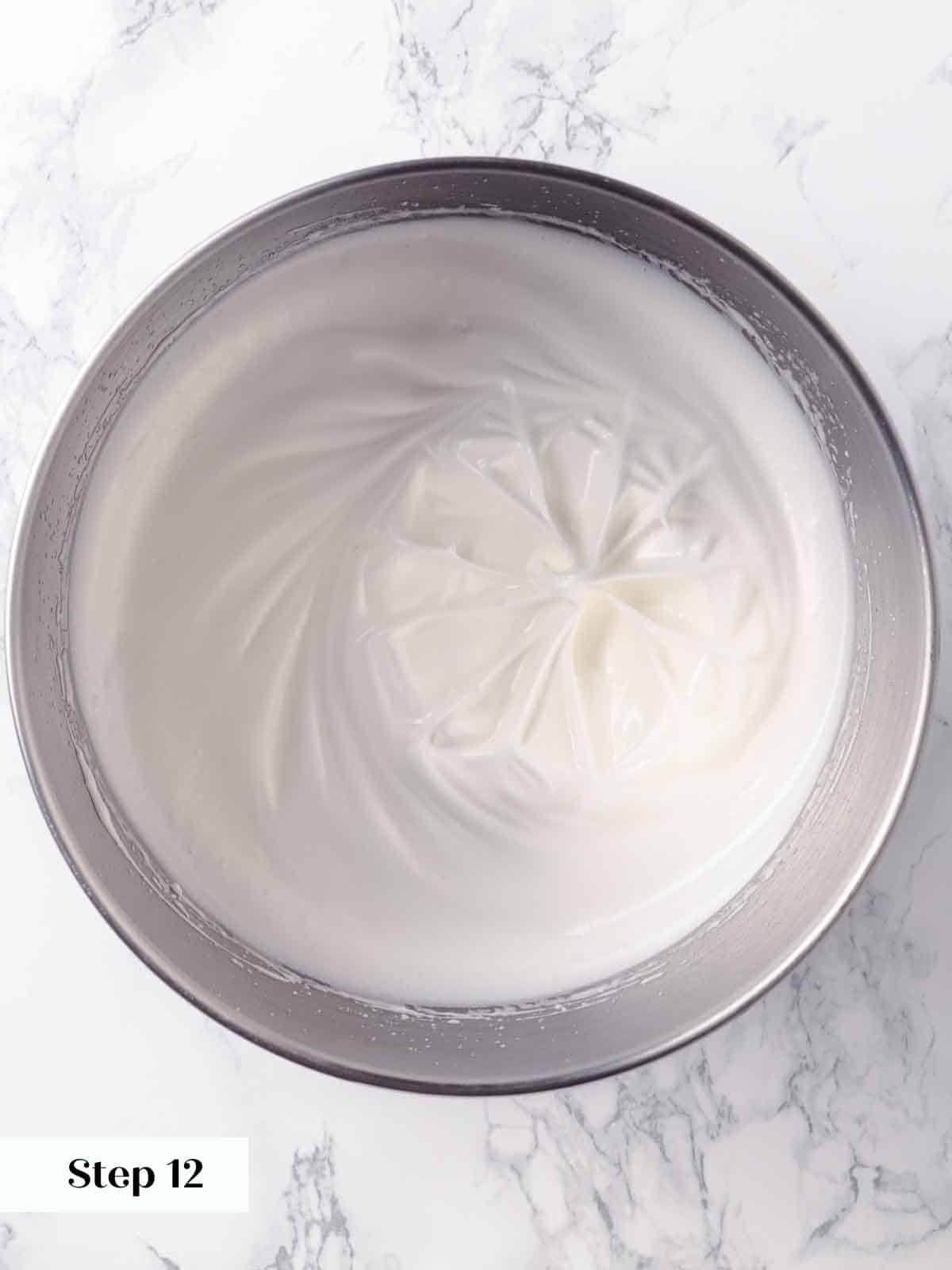 Egg whites beaten to a fluffy consistency, forming soft peaks in preparation for meringue.