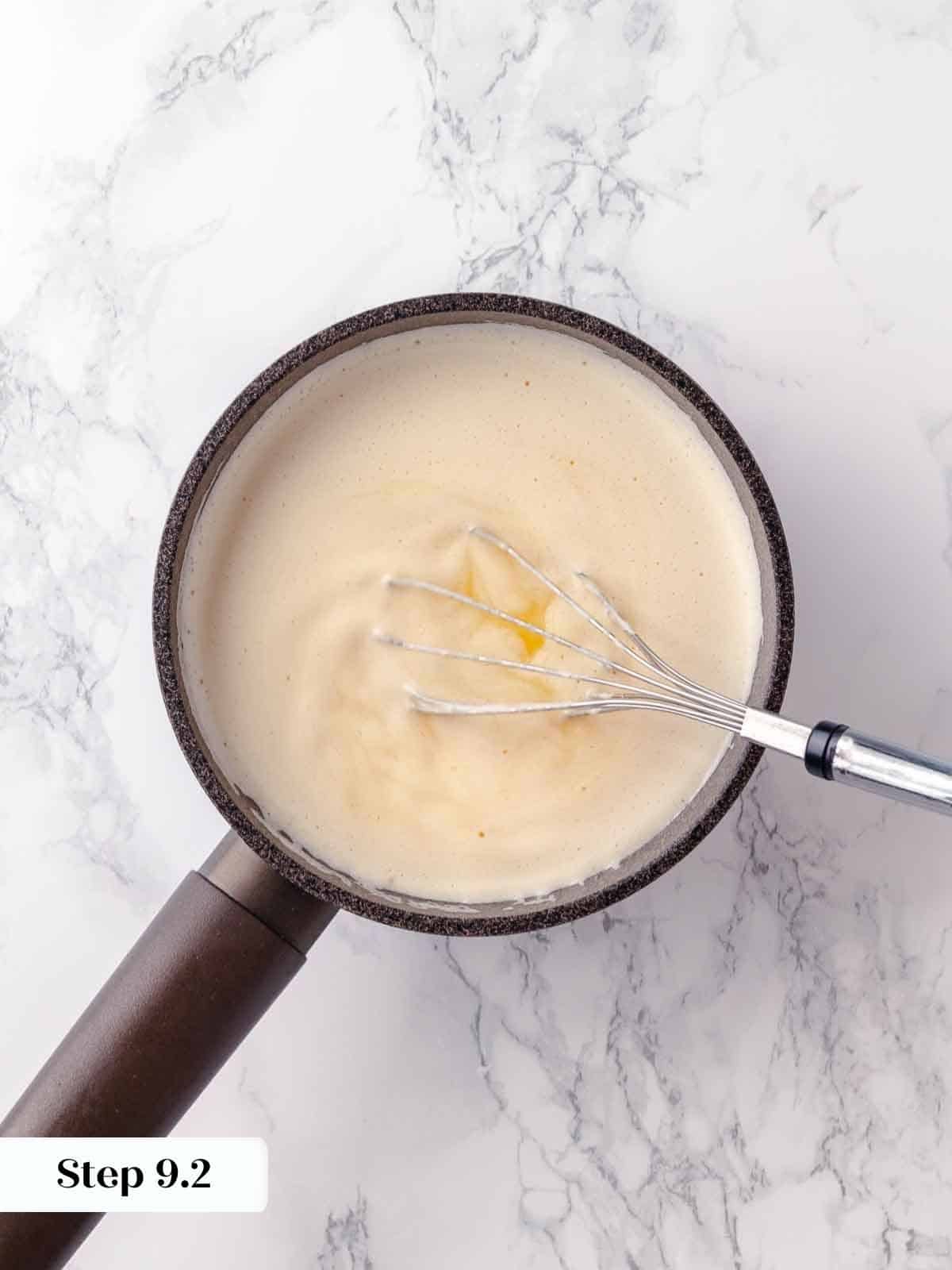 Butter being whisked into a lemon mixture to create a glossy pie filling.