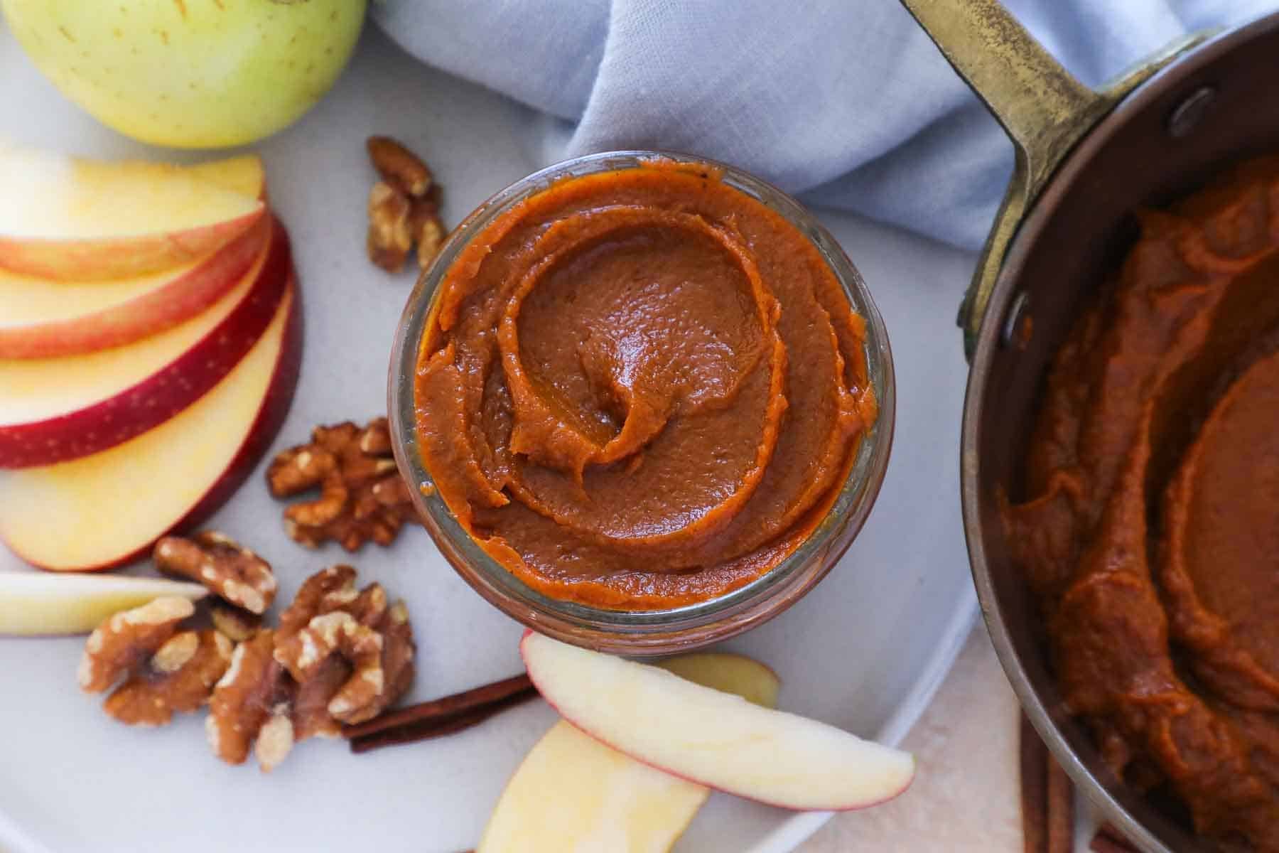 arrangement of nuts, fruits and pumpkin butter on plate with blue napkin.