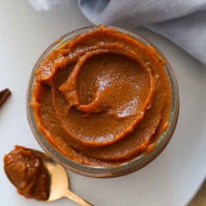 jarred pumpkin butter with swirl on top and spoon.