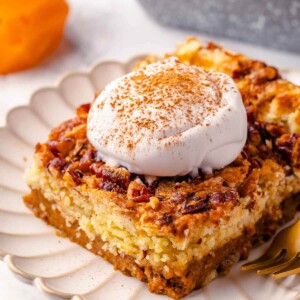 A slice of pumpkin dump cake served on a white plate with a clean presentation.