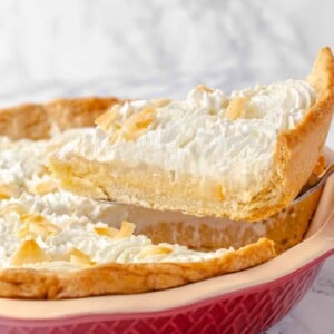 Slice of coconut cream pie served on a pie server.