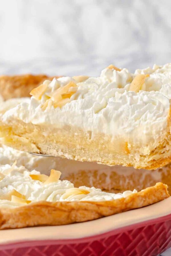 Slice of coconut cream pie served on a pie server.