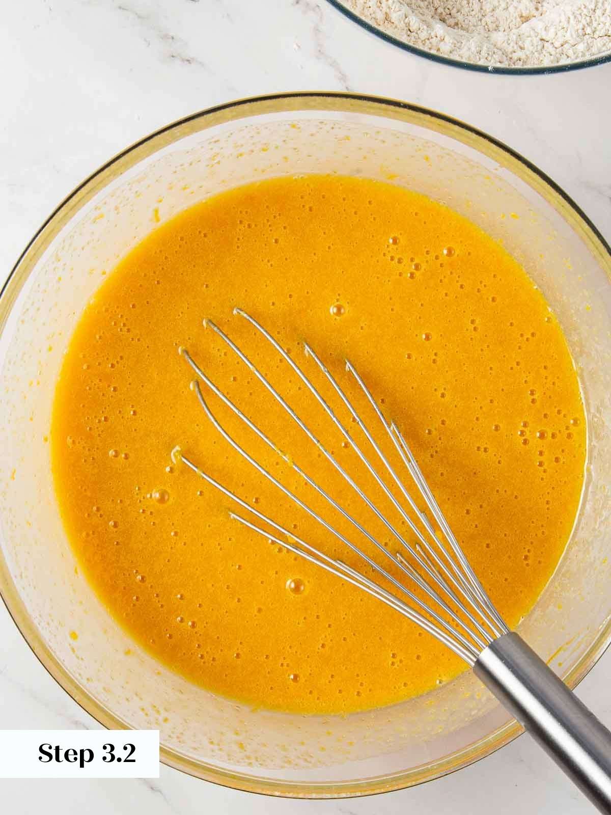 Wet ingredients for pumpkin bread fully combined in a mixing bowl.