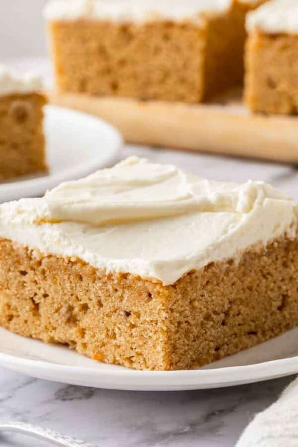 A close-up of cream cheese frosting swirled beautifully over the top of a banana cake.