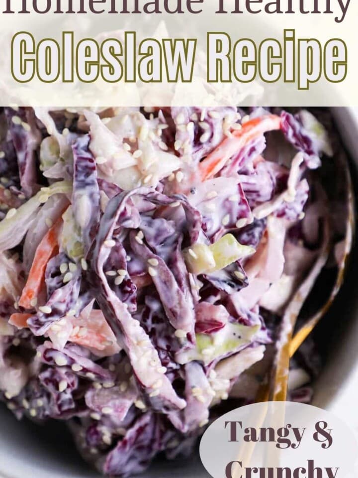 Creamy coleslaw served in a white bowl on a wooden table.