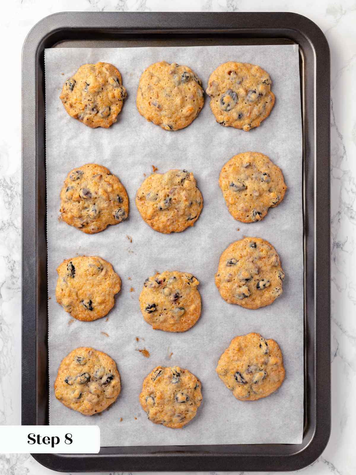 Hermit cookies fresh out of the oven, golden and slightly puffy on a baking sheet.