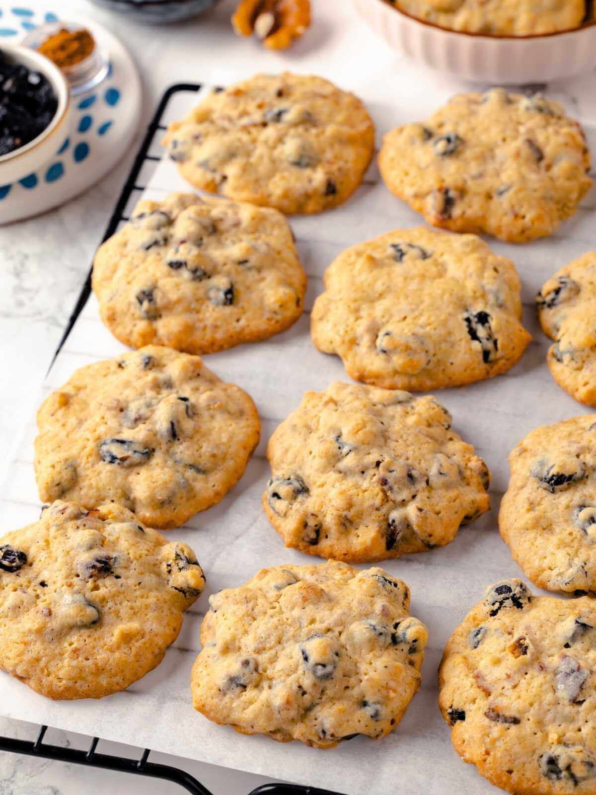 Freshly baked hermit cookies cooling on a wire rack after coming out of the oven.