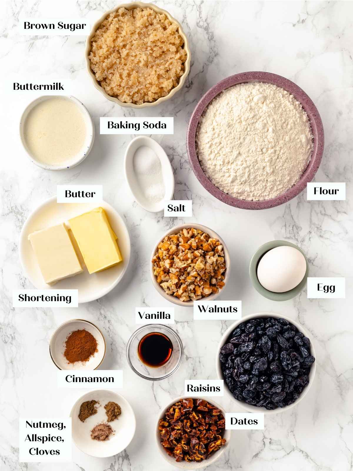 A flat lay of ingredients for hermit cookies, spread on a white marble surface.