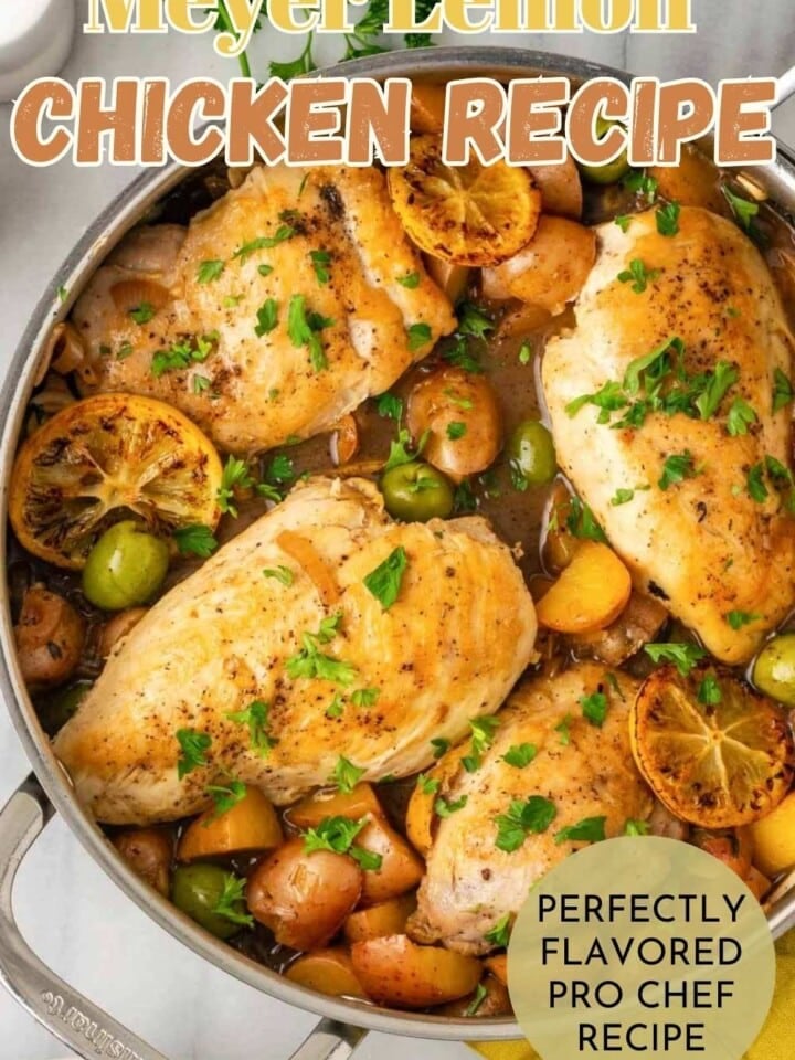A skillet of lemon chicken with sauce and fresh herbs.