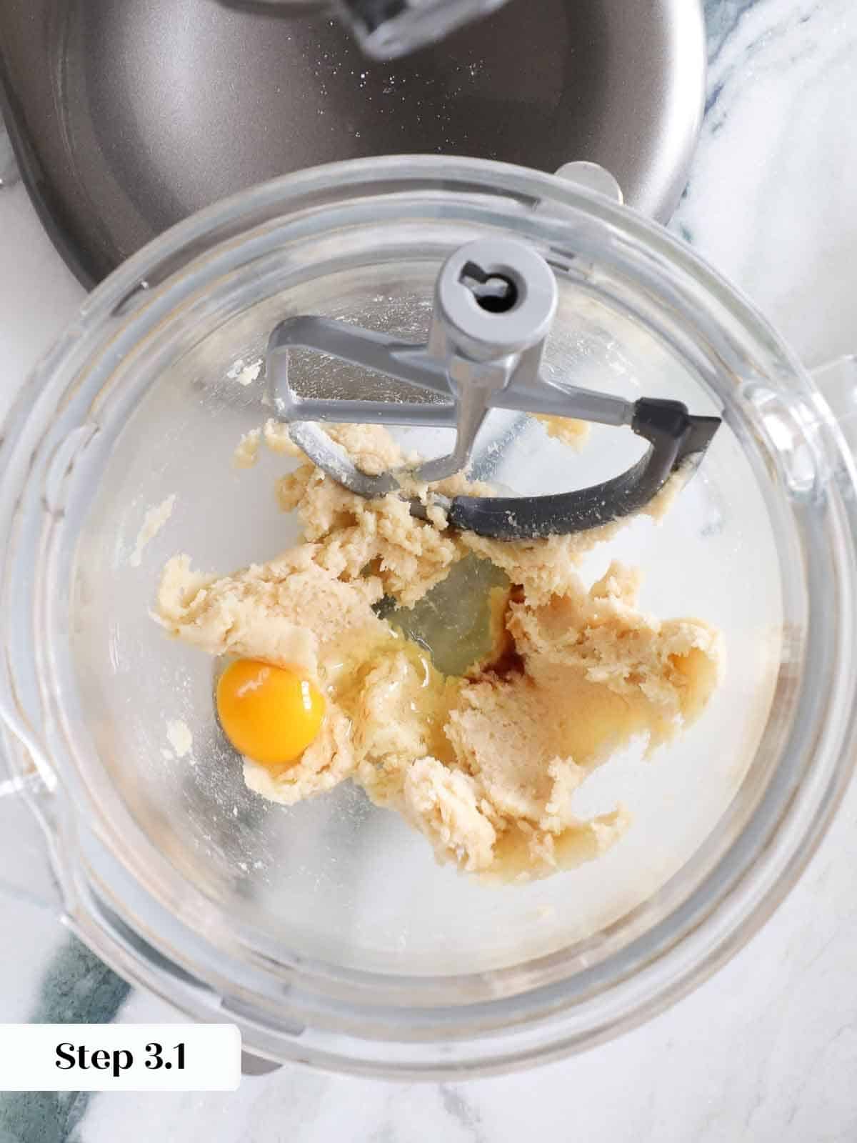 A raw egg cracked into a mixing bowl, ready to be combined with other monster cookie ingredients.