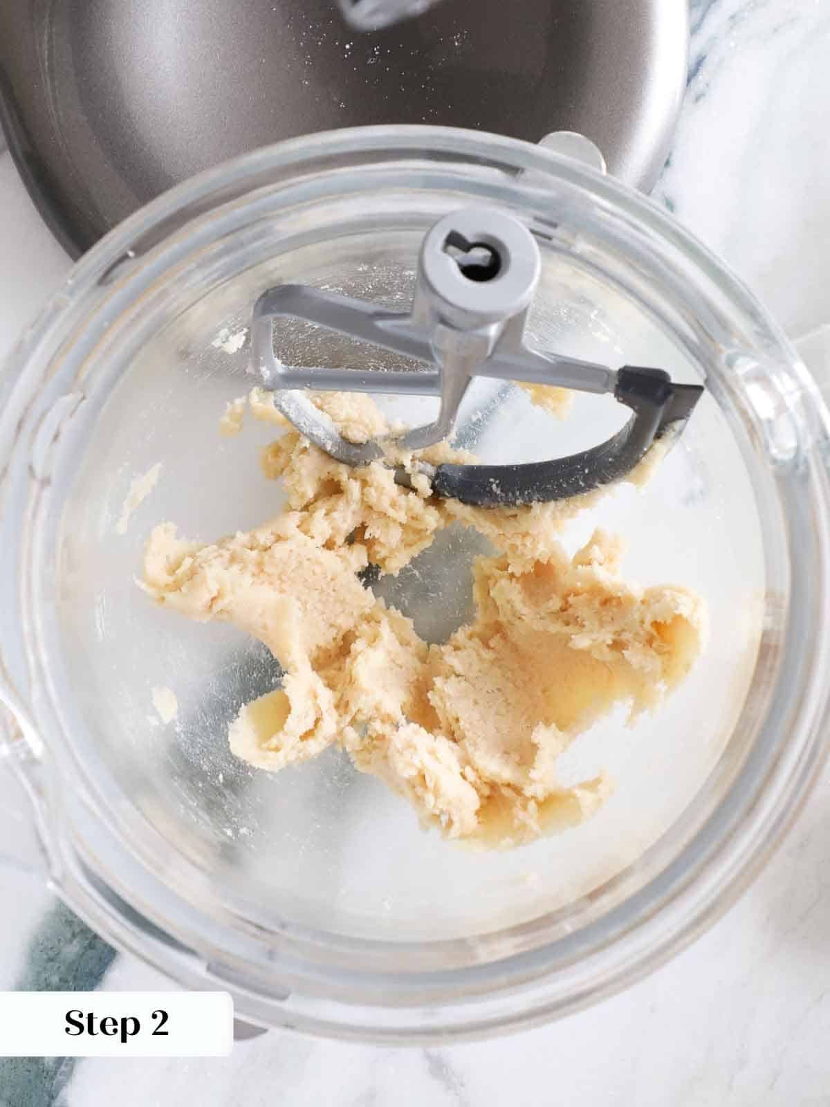 Butter and sugars creamed together in a mixing bowl to form a smooth base for monster cookie dough.