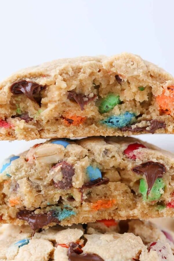 A close-up of a thick monster cookie, emphasizing its hearty, chewy layers.