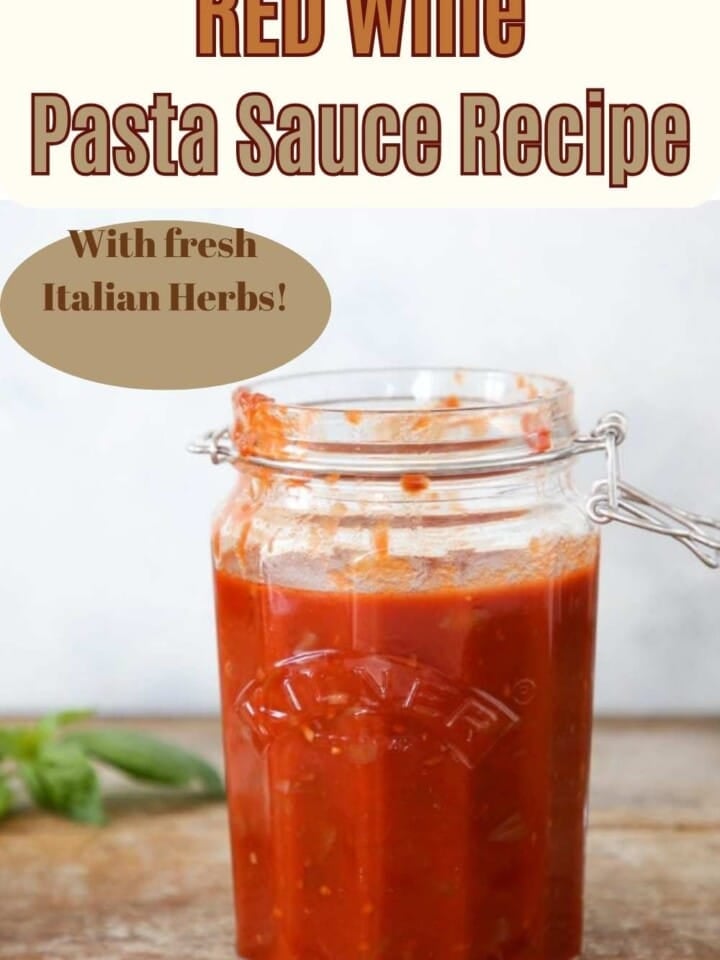 A jar of red wine tomato sauce with basil leaves.