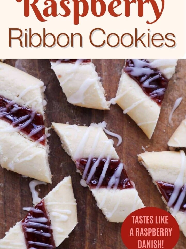A close-up of raspberry ribbon cookies with a buttery base and jam filling arranged on a wood surface.