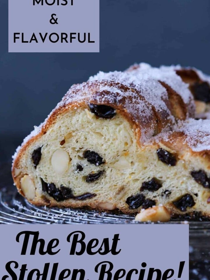 Close-up of classic stollen bread with golden crust, dried fruit, and festive powdered sugar topping.