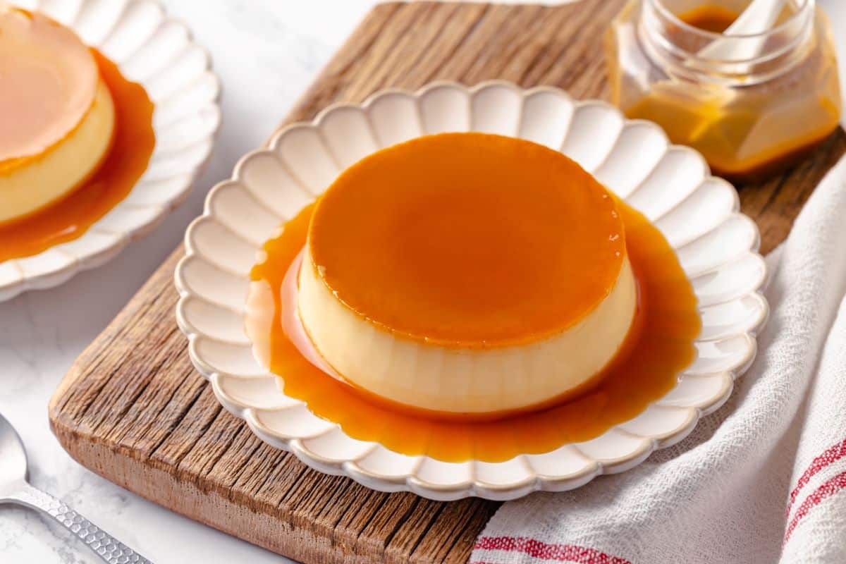 A beautifully plated creme caramel dessert served with its caramel sauce pooling around it.