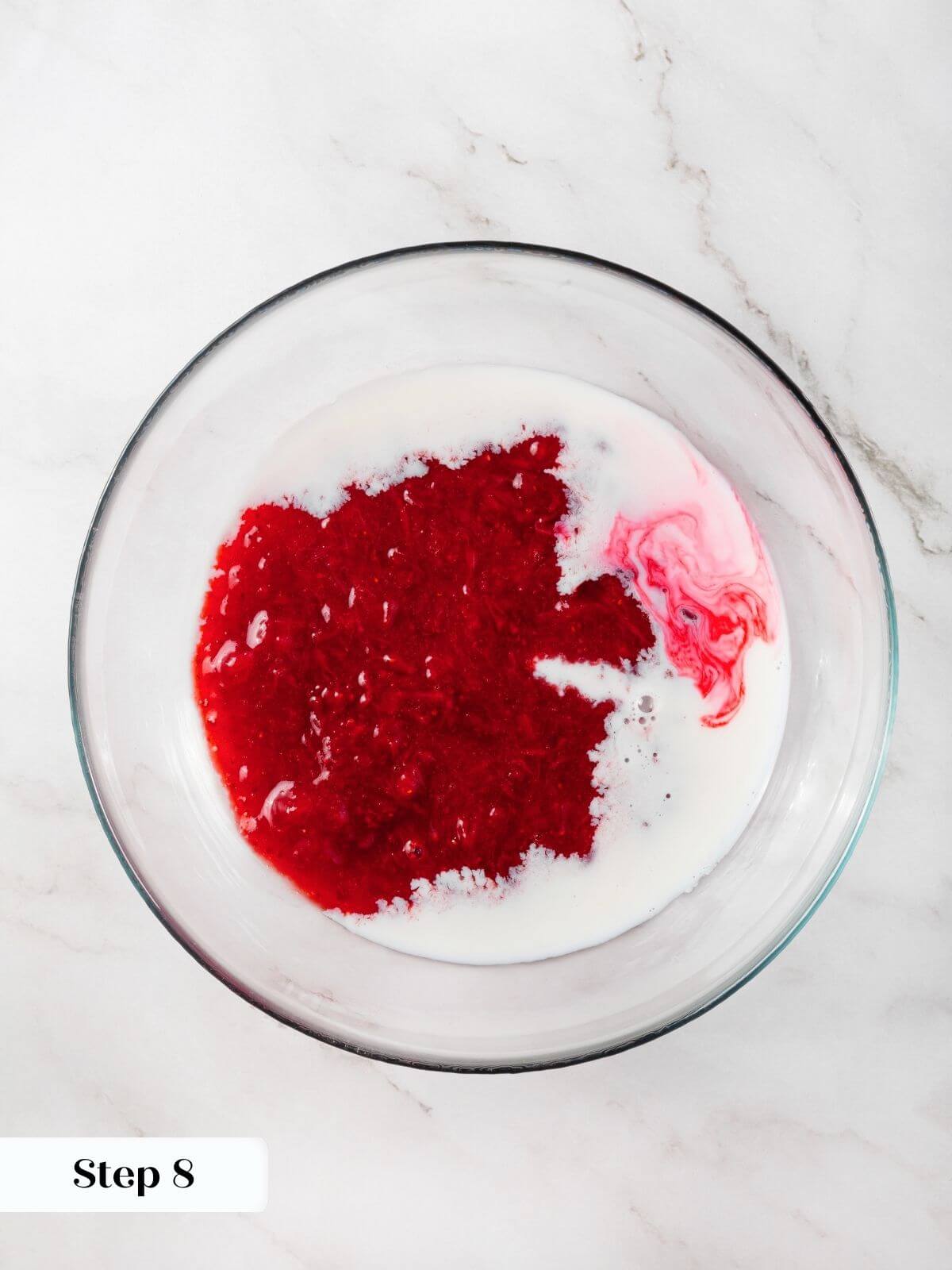 Milk being combined with strawberry jam to infuse the batter with fresh strawberry flavor.