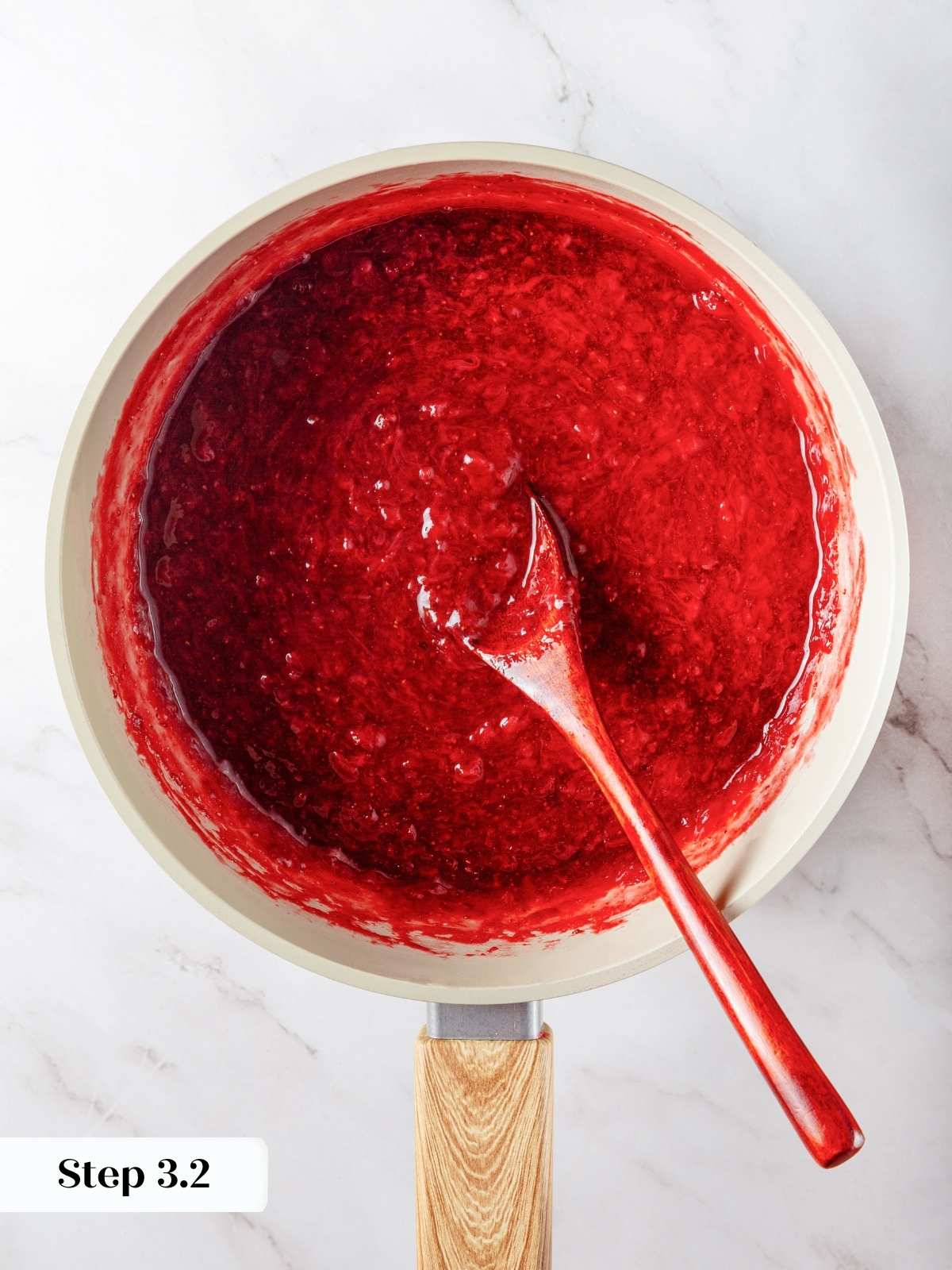 Freshly mashed strawberry jam with a glossy texture, ready to cool and use.