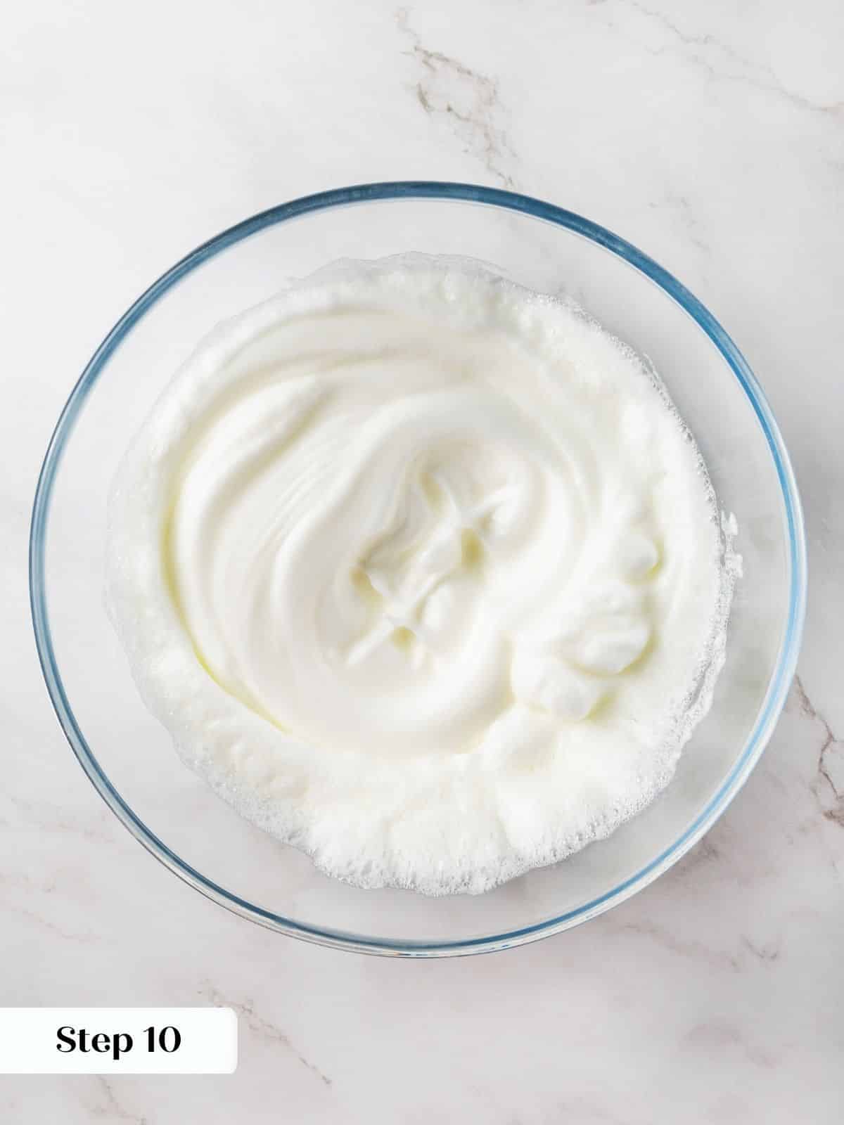 Egg whites whisked in a mixing bowl for light and fluffy cupcakes.