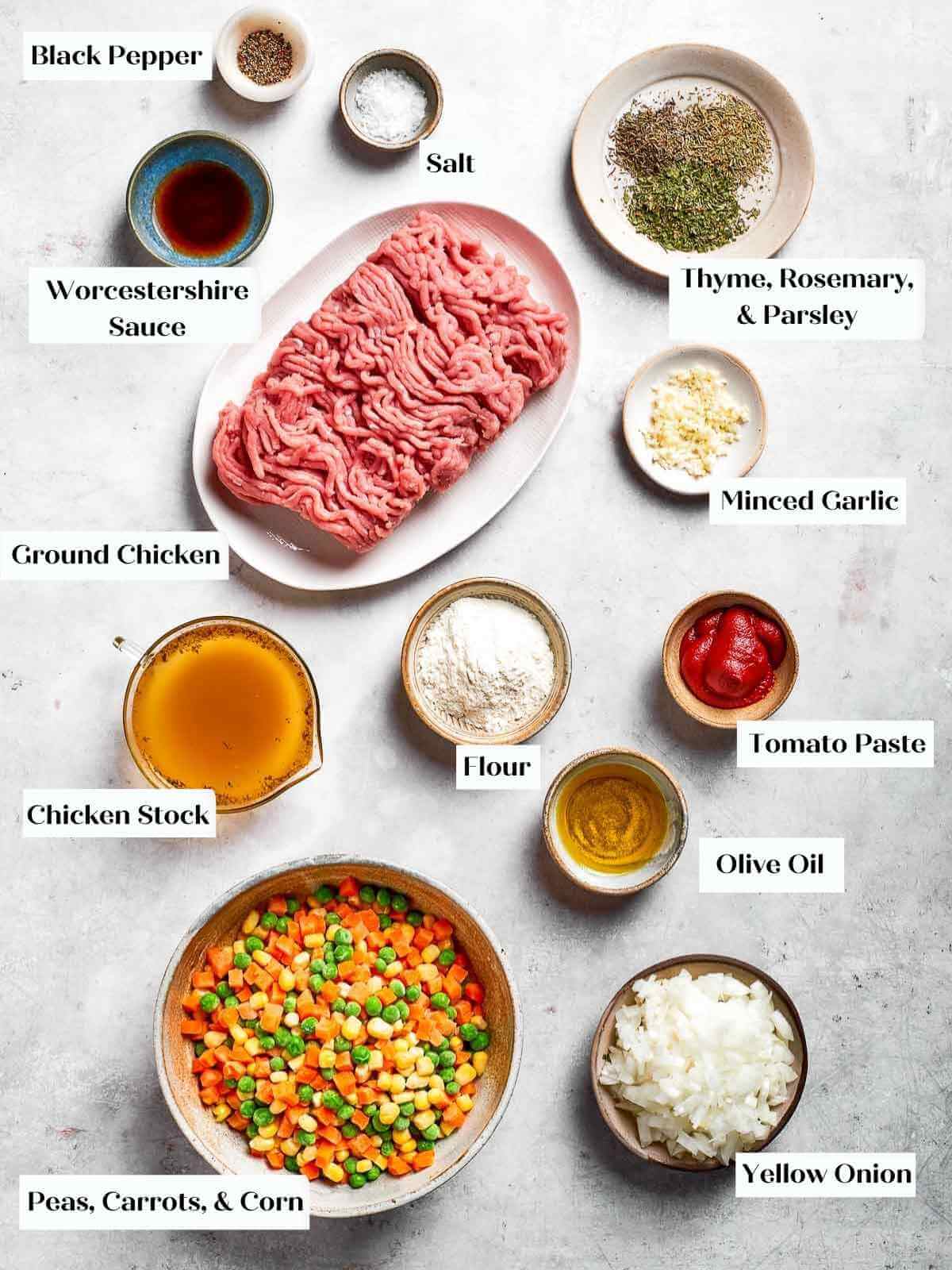 A full ingredient spread for making Chicken Shepherd’s Pie, showcasing fresh herbs, chicken, seasonings, and more.