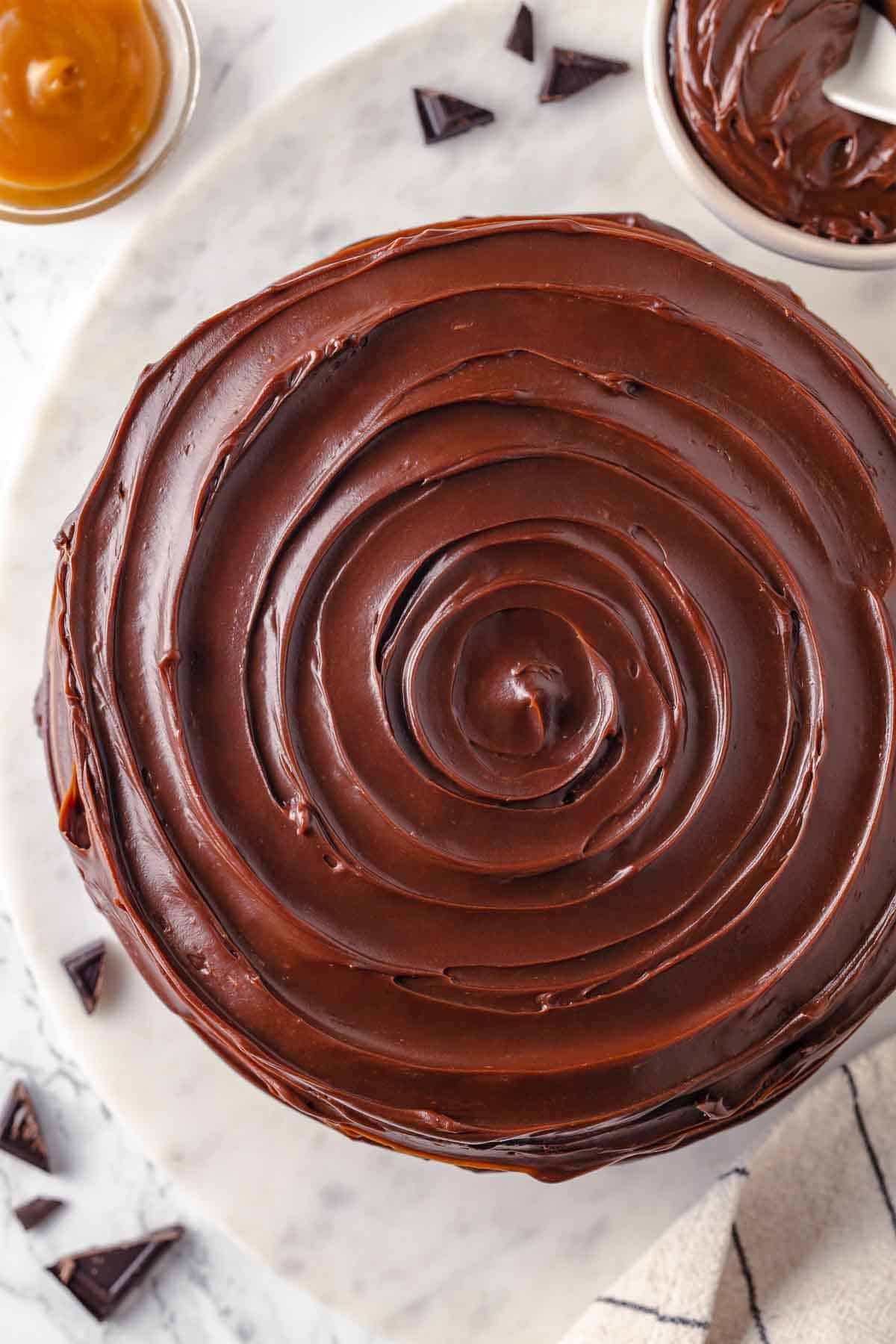 swirled caramel fudge frosting on guinness chocolate cake unsliced.