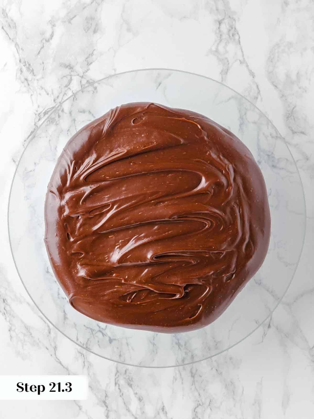 spreading frosting between layers of guinness chocolate cake during assembly.