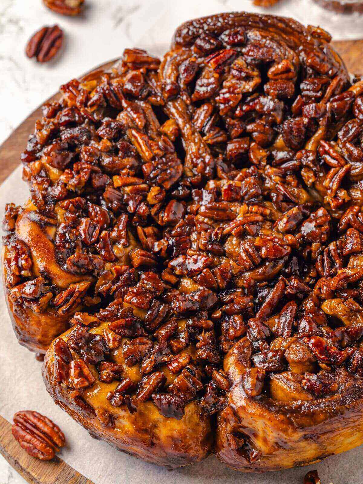 Close-up of sticky buns with glossy, caramelized pecan topping.