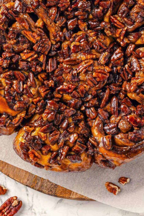 Whole pecans scattered on a caramelized surface after baking.